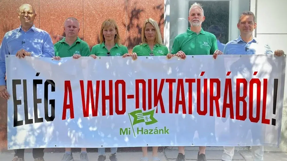 A fénykép a WHO budapesti székháza előtt készült, melynek ünnepélyes átadását sikerült megakadályoznia a Mi Hazánknak, pedig Szijjártó Péter 2023-ban hirdette meg a WHO-főigazgatóval való irodaátadás tervét.