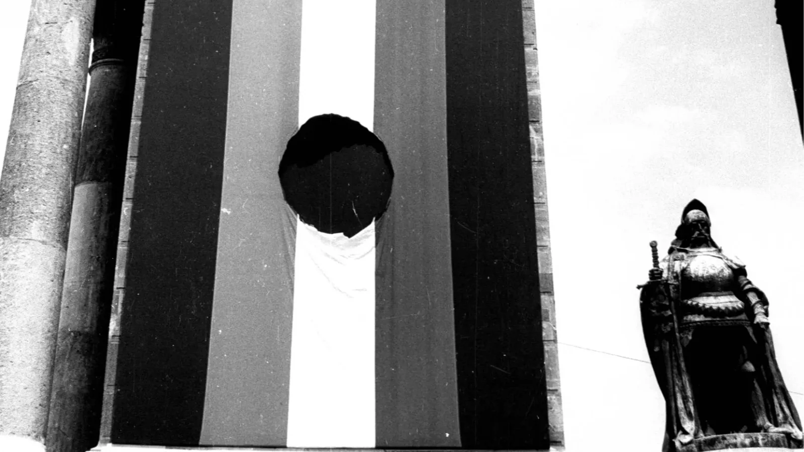 The tattered flag at Heroes’ Square on the Millennium Monument on June 16, 1989, during the reburial of Imre Nagy and the martyrs of the 1956 Revolution.